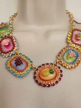 Welcome to Betsey's backyard with this colorful bib necklace featuring striking